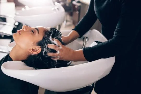 Woman enjoying a professional hair wash and scalp care treatment at a modern salon